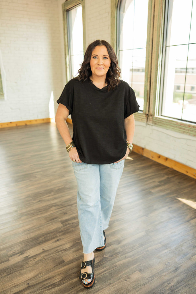 plus sized Woman wearing a black rolled sleeve basic tee top styled with jeans
