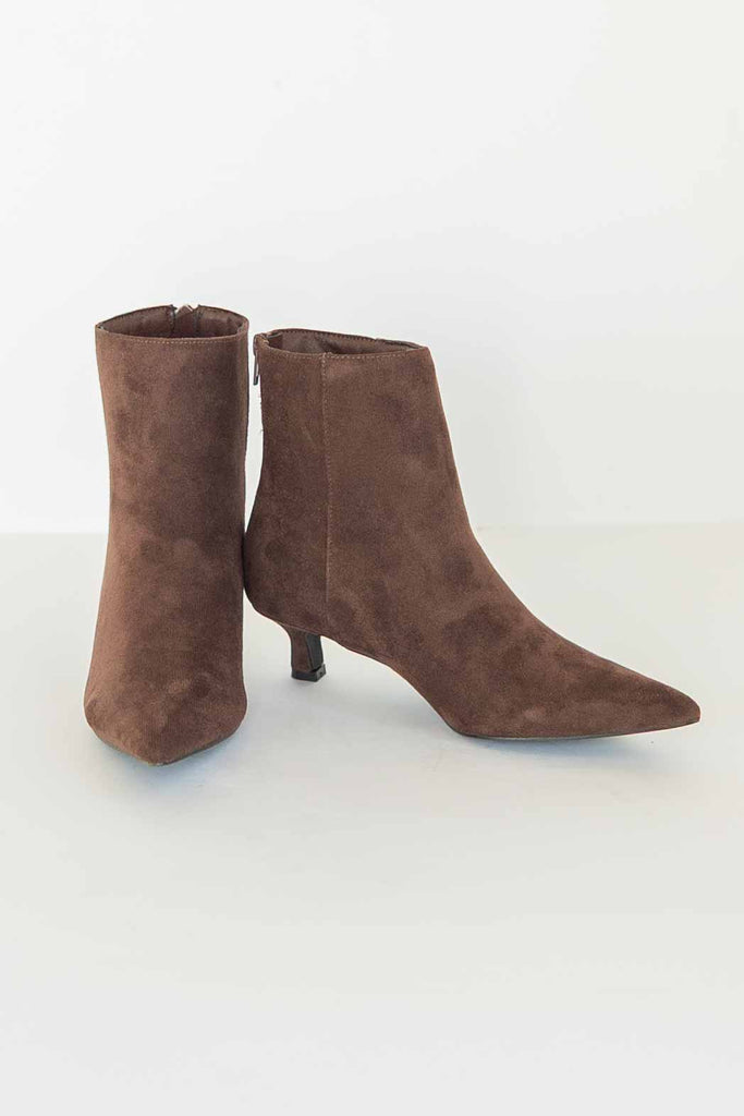 Pair of chocolate brown suede-look ankle booties with pointed toe and low kitten heel.