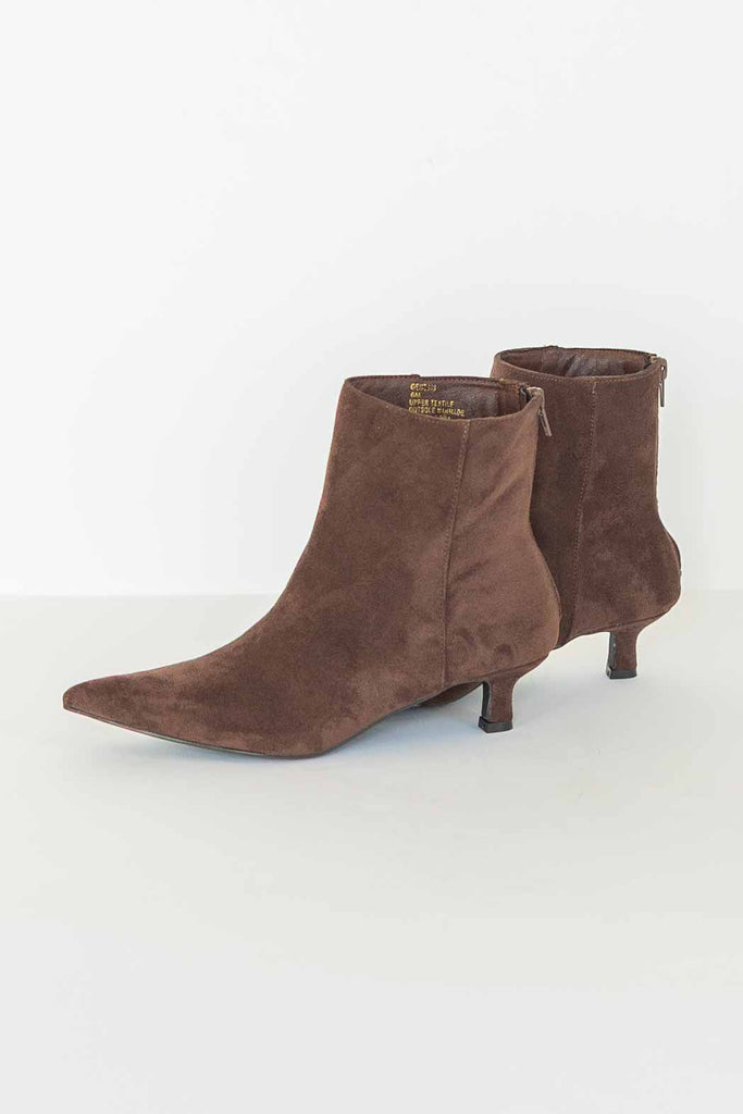 Pair of chocolate brown suede-look ankle booties with pointed toe and low kitten heel.