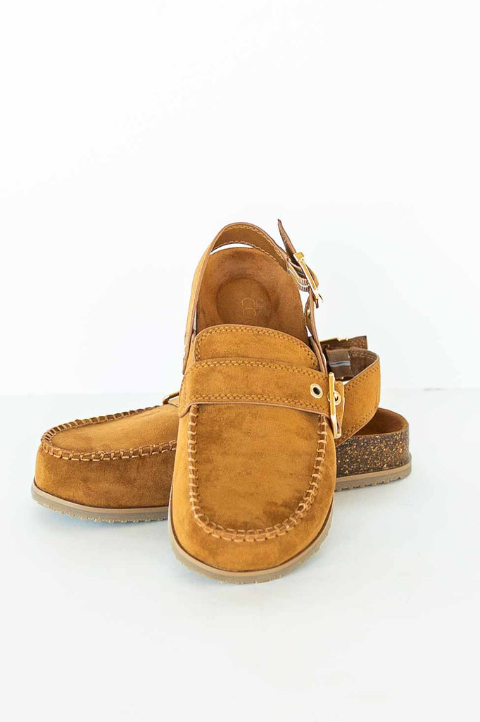 Brown faux suede clog with gold buckles, slingback strap, and faux cork midsole on a white background.