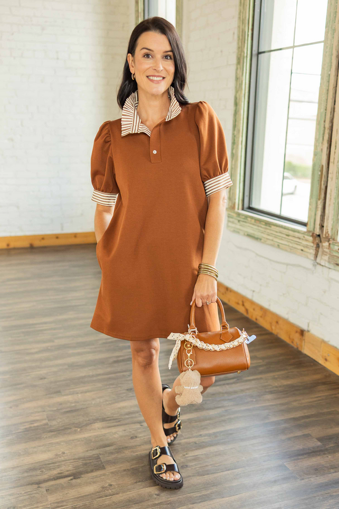 Kandace wearing chestnut brown short sleeve polo-style mini dress with striped tan and cream contrast collar and cuffs.