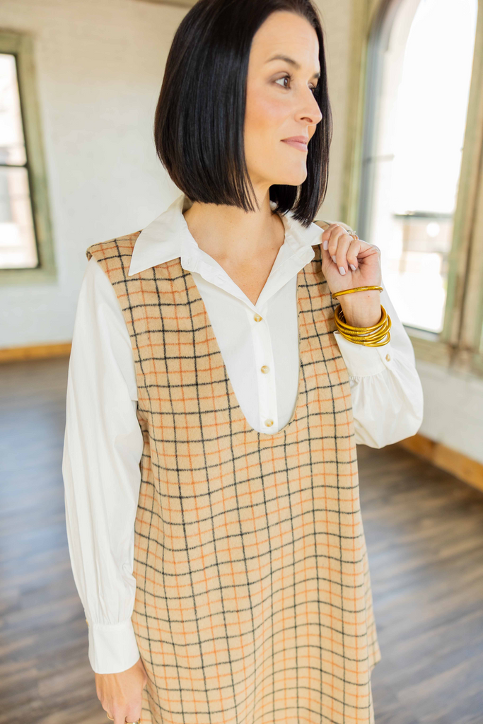 wearing the Teagan tan plaid two-fer mini dress with built-in white undershirt and tall tan boots
