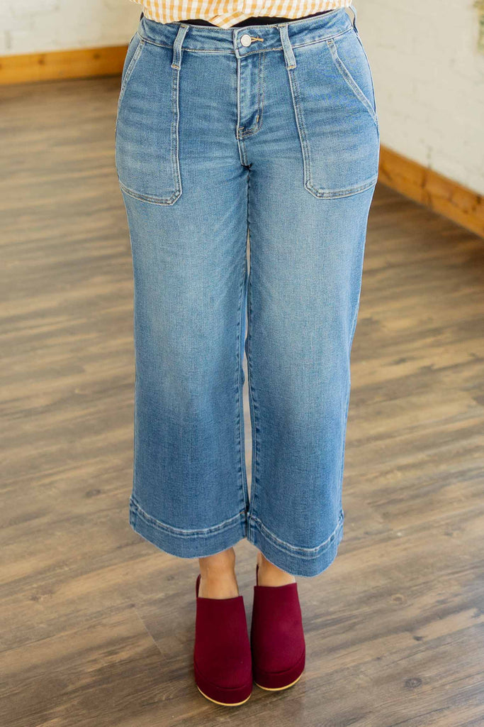 Kayla wearing the Lovervet Serenity medium wash crop wide leg jeans with utility pockets and burgundy clogs 