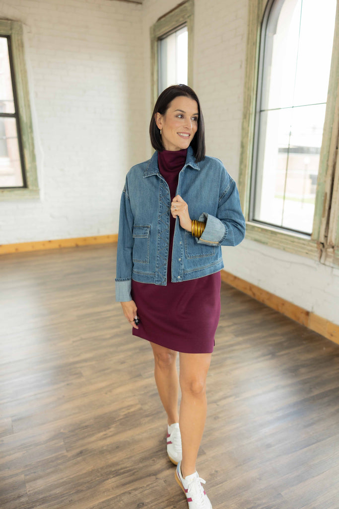 Kandace wearing the Isabel denim snap button jacket layered over a plum mini dress