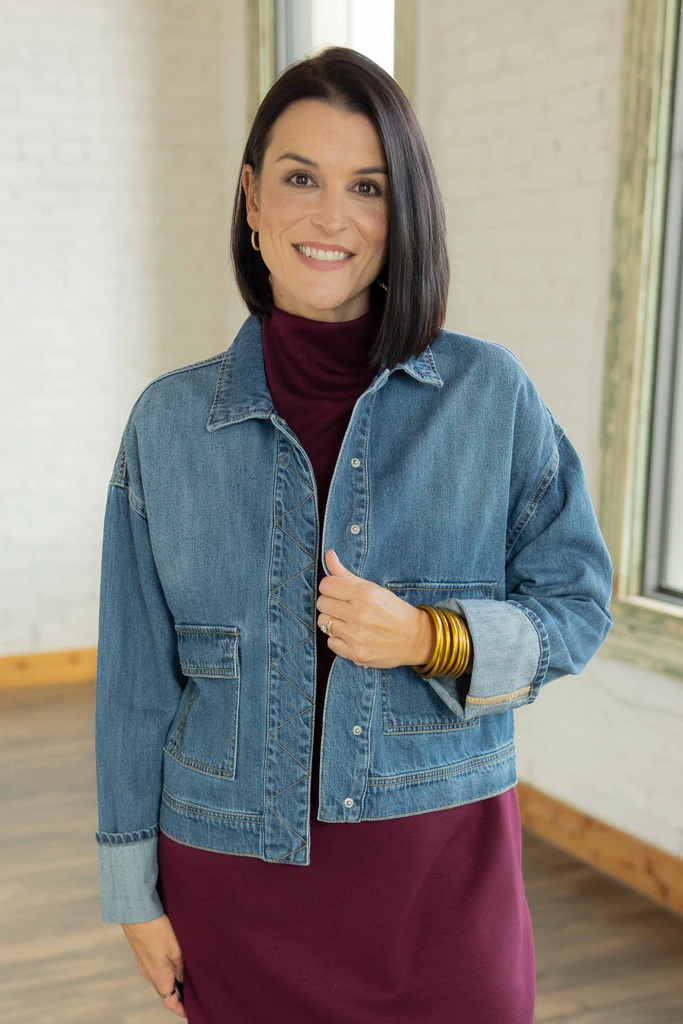 Kandace wearing the Isabel denim snap button jacket layered over a plum mini dress