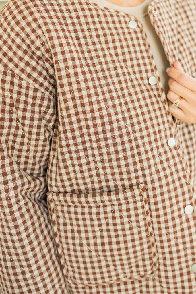 Kandace wearing the Julieta gingham puff snap button jacket in brown and cream checkered print, styled with mint floral pants