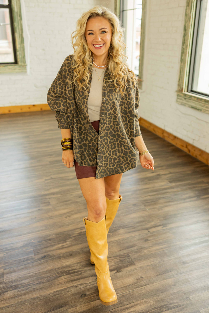 Holly wearing the Emely Leopard Print Button Up Long Sleeve Shacket, an oversized brown and black leopard print shirt jacket with front buttons and a high-low hem, styled with a mini skirt and tan boots.