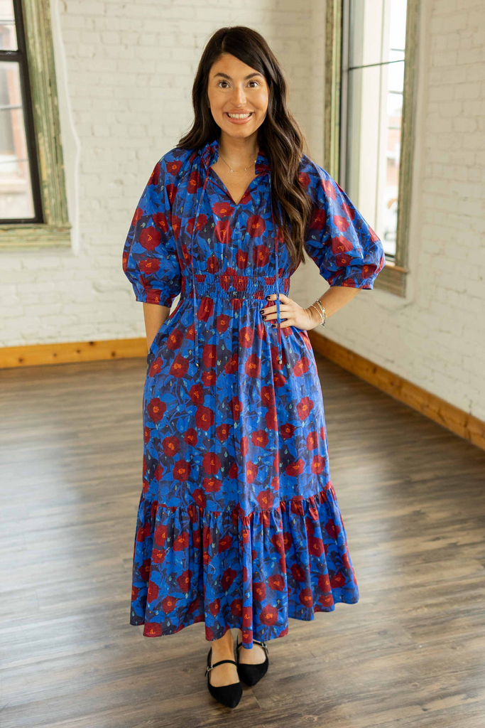 Kayla wearing the Ashley Floral Smocked Waist Maxi Dress, a cobalt blue maxi dress with red floral print, smocked waist, and 3/4 sleeves.