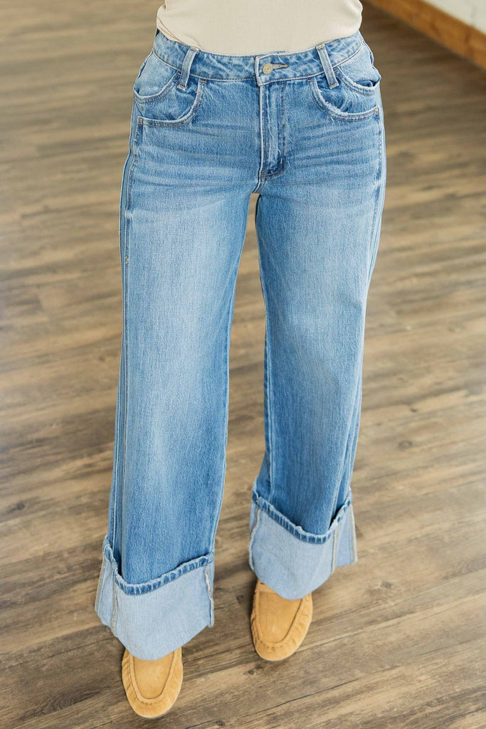 Holly wearing the [VERVET] Kris Dark High Rise Cuffed Baggy Wide Leg Jeans, dark wash wide-leg jeans with a single cuffed hem and double front pockets, styled with a caramel ribbed top and tan shoes.